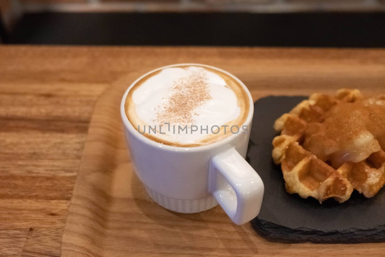 Waffle and cup of coffee on wooden table