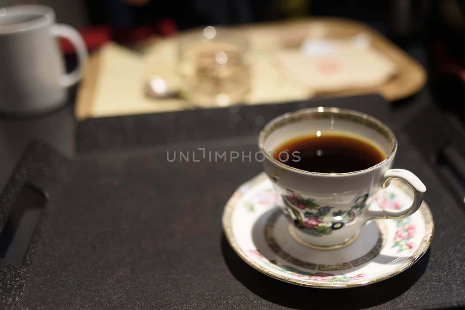 Cup of coffee on black tray by uphotopia