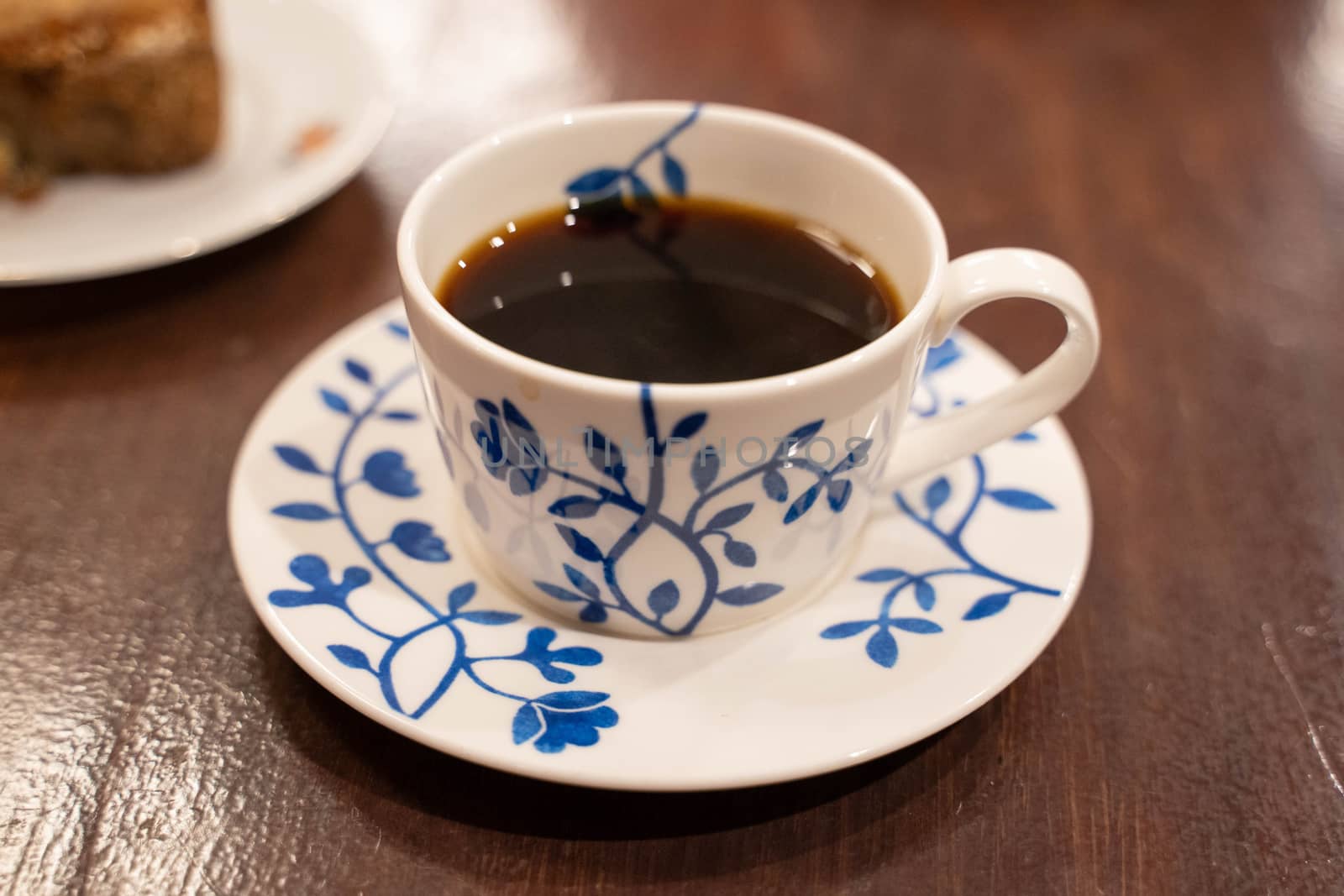 Cup of coffee on wooden table by uphotopia