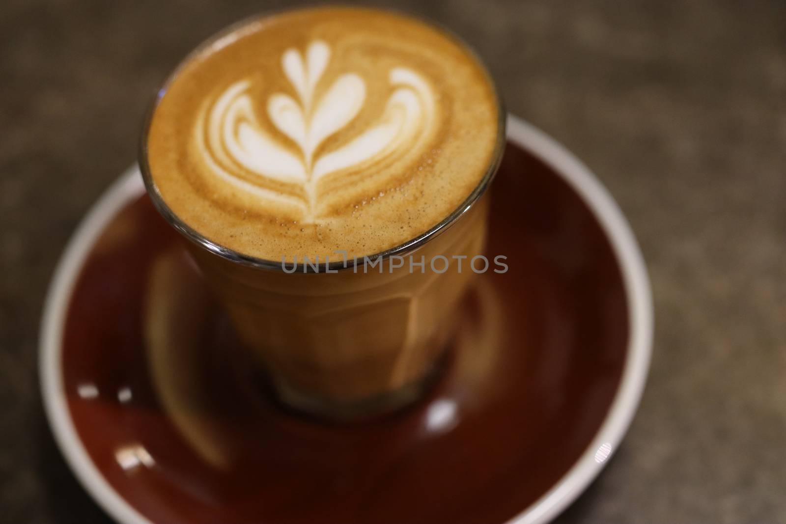 Cup of coffee with latte art on tray