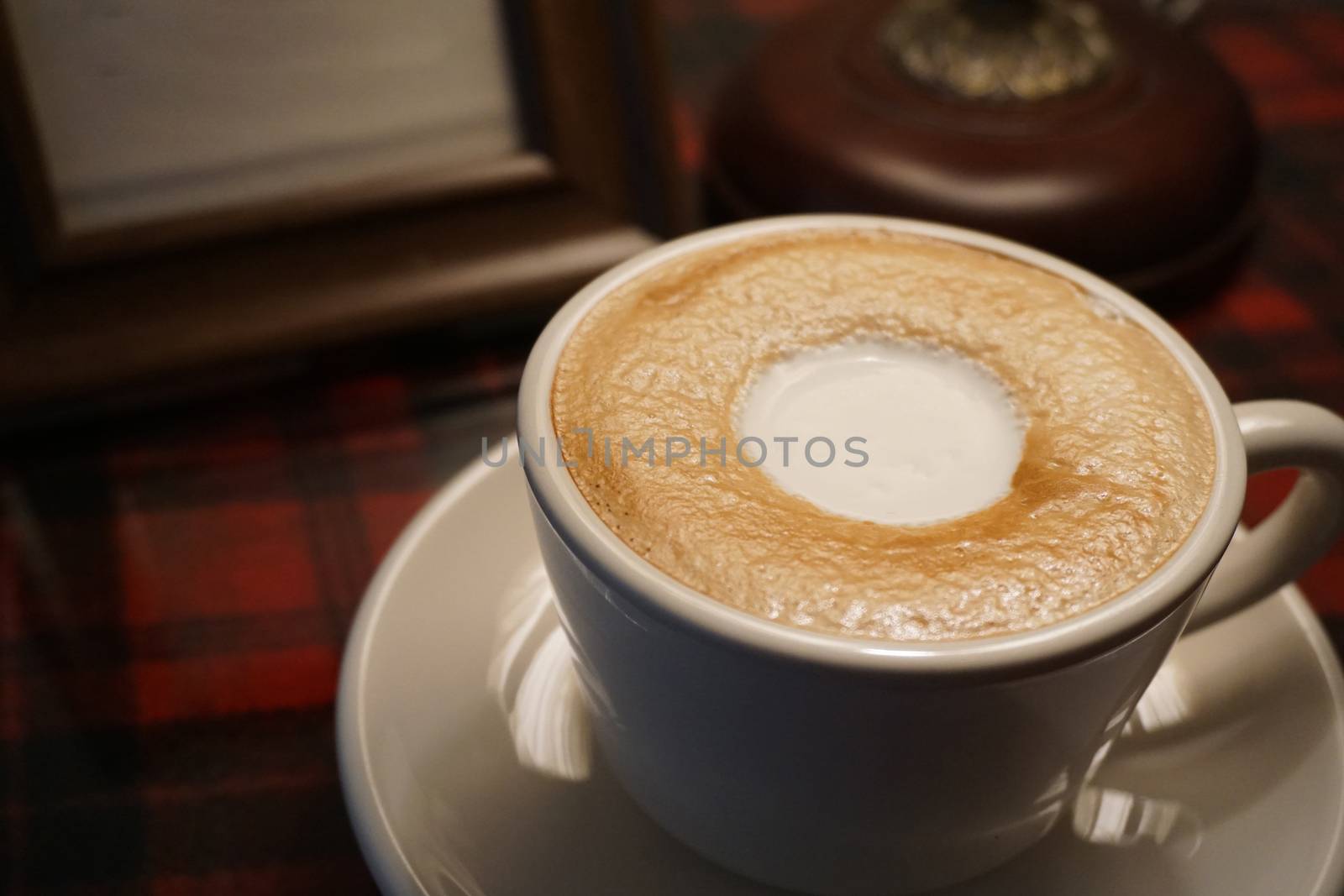Cup of coffee with latte art on table by uphotopia