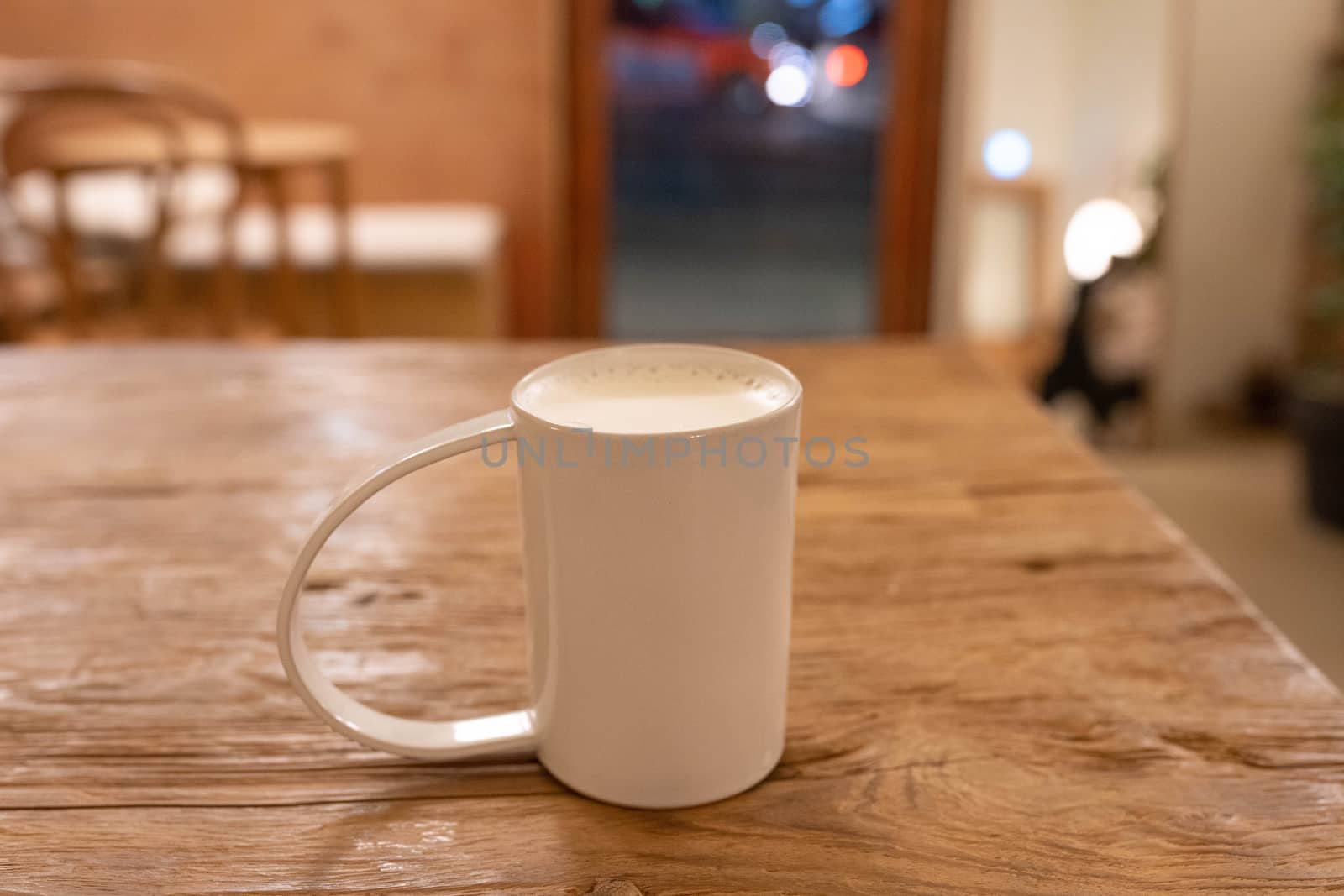 Cup of steamed milk on wooden table