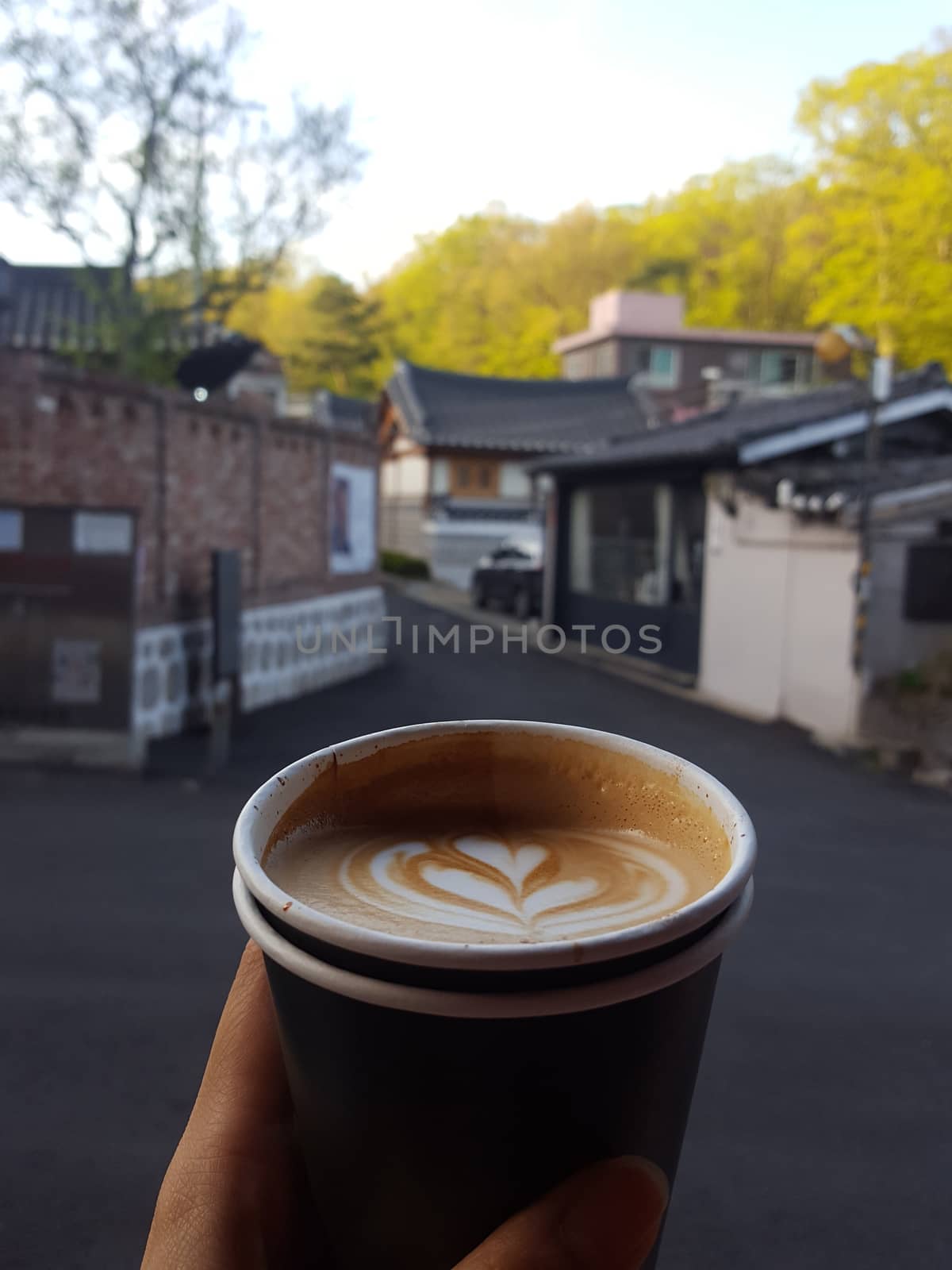 Hands holding cup of coffee by uphotopia