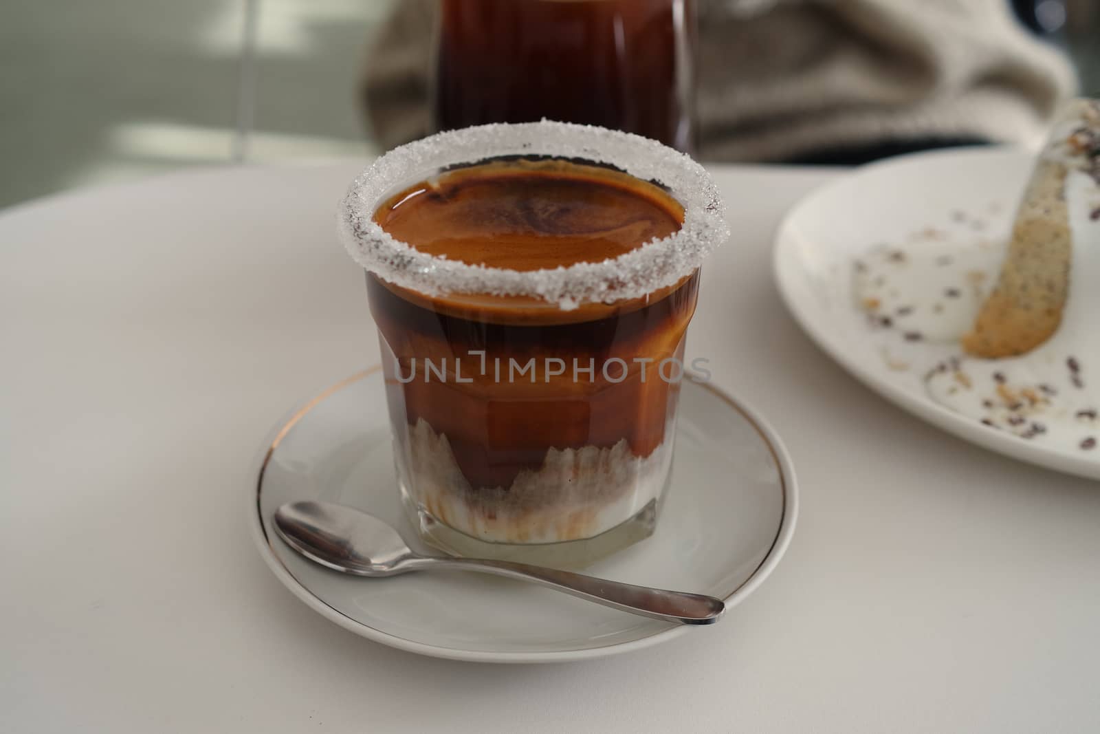 Spoon and cup of coffee on table