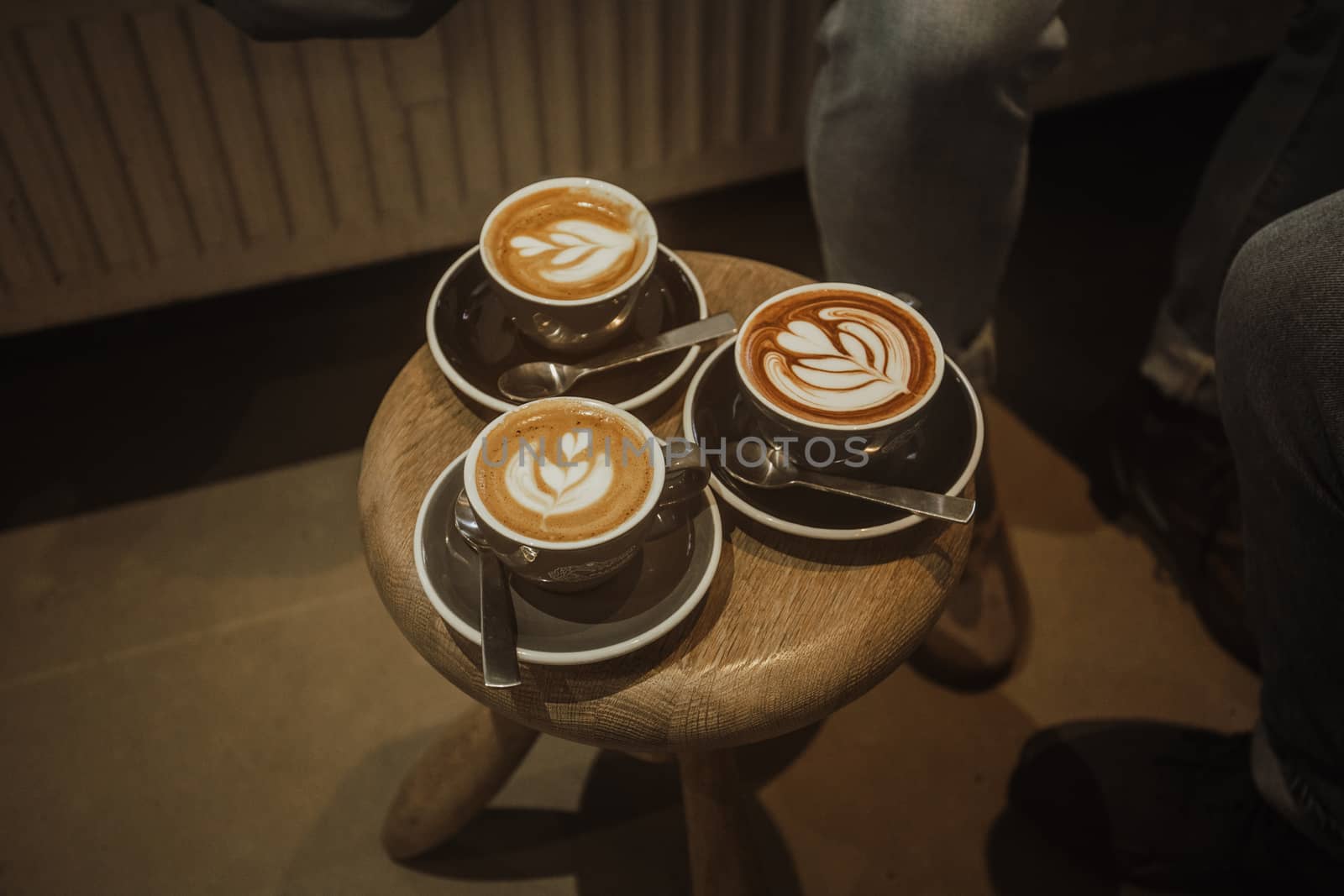 Three cups of coffee on wooden table by uphotopia