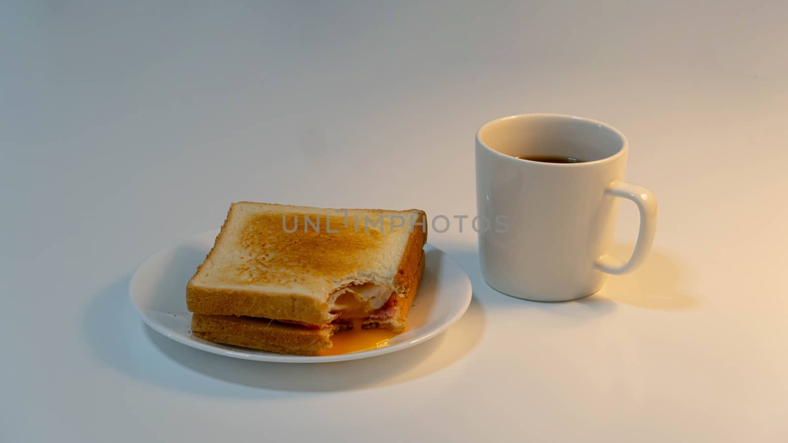 Toast and cup of coffee on white background by uphotopia
