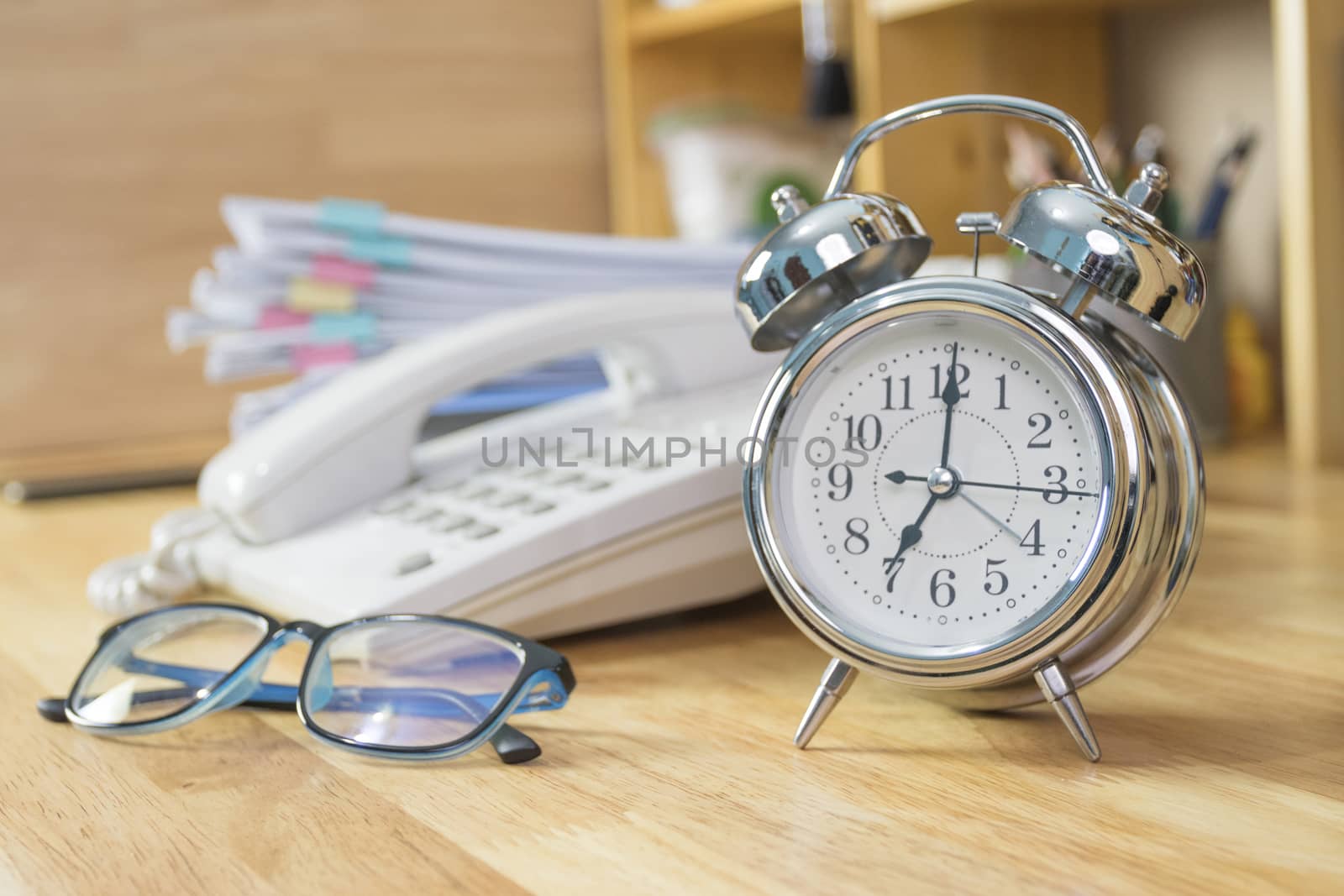 clock on work desk  in the work office Time of working concepts office life on morning, selective focus the clock