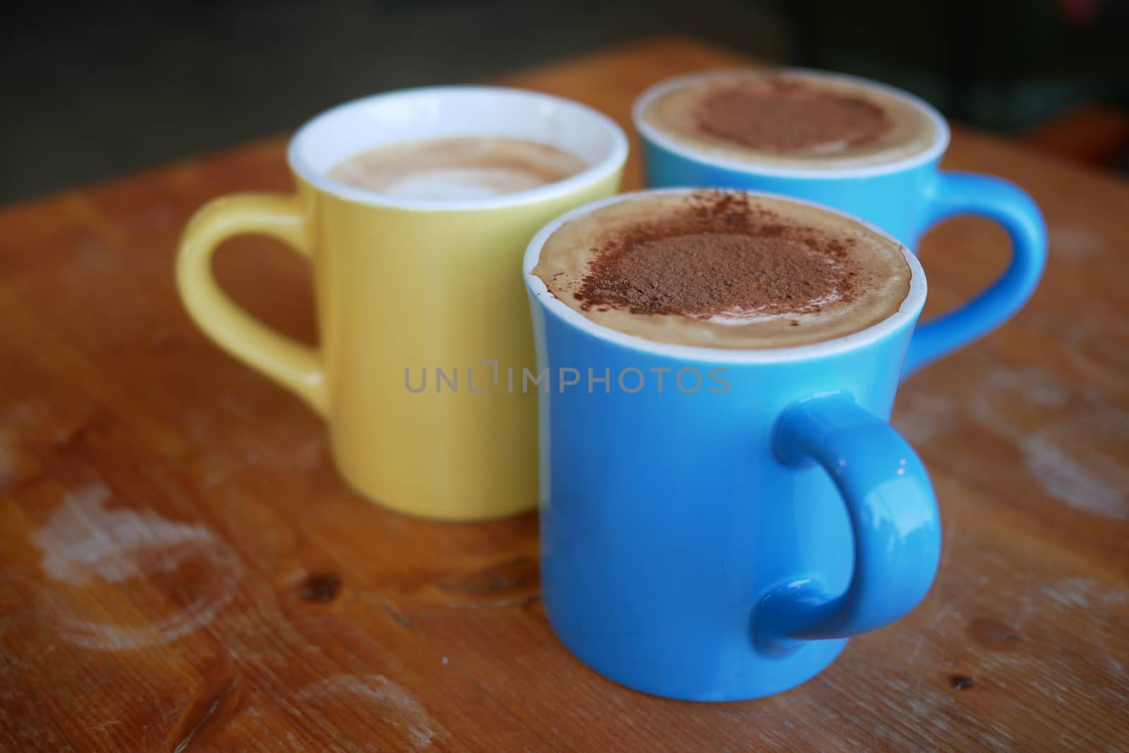 Three cups of coffee on wooden table by uphotopia
