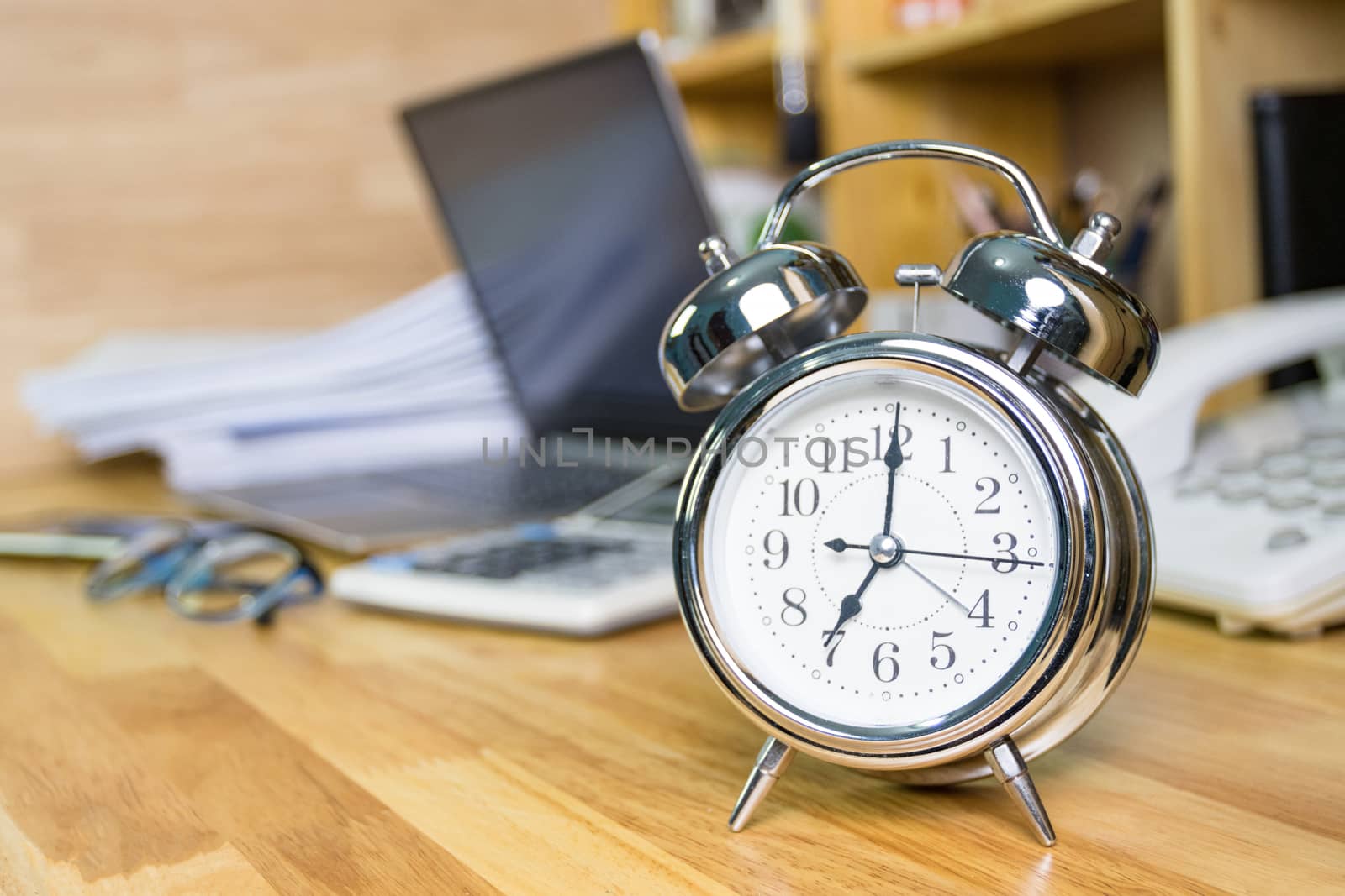 clock on work desk  in the work office Time of working concepts office life on morning, selective focus the clock