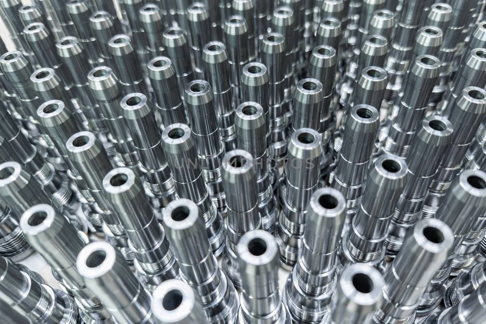 Shiny long steel parts full frame background, clean steel threaded rods after fine cnc turning.