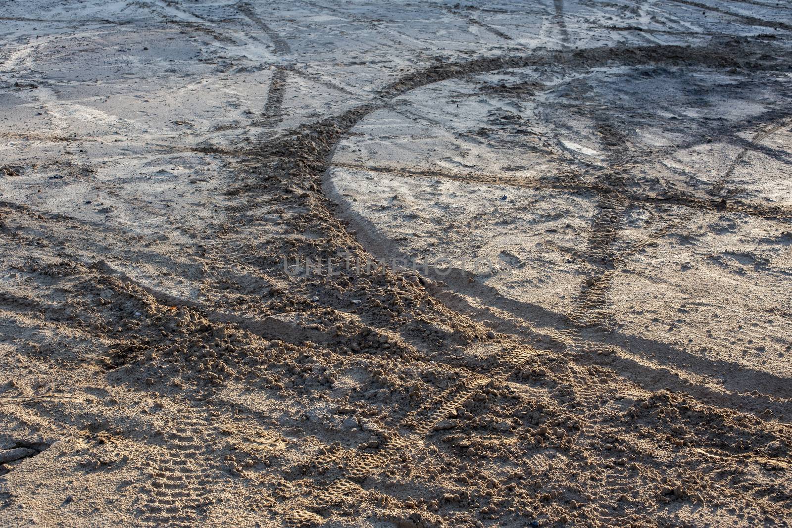 dry sand and mud ground with many dirt bike tracks at daylight.