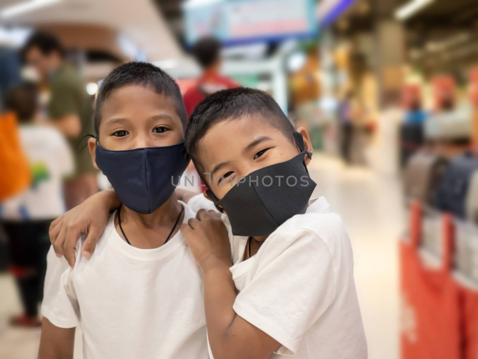 Two boy wearing a protective mask While in the mall. by Unimages2527
