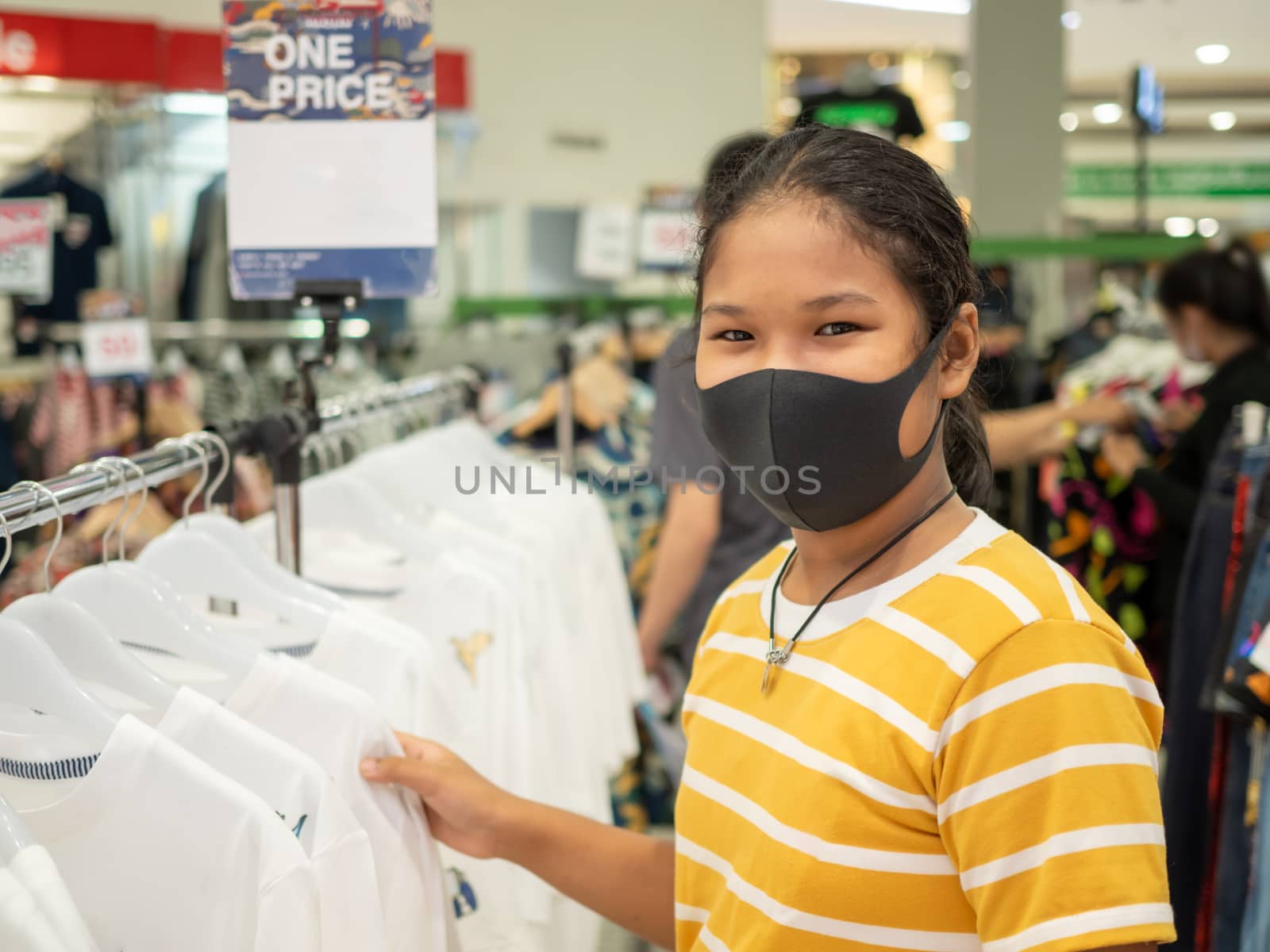 A woman wearing a protective mask While choosing a product In the mall.