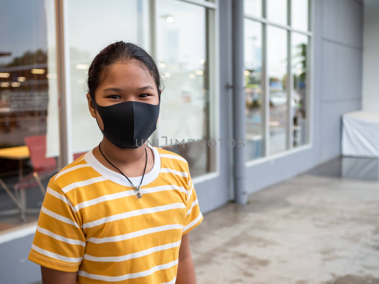 A woman wearing a protective mask While walking in the mall. by Unimages2527