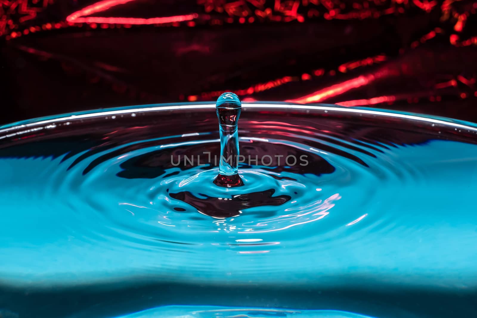 Abstract background. Water splash close-up. A frozen drop above the surface of the water. Drop of water. The frozen spray.