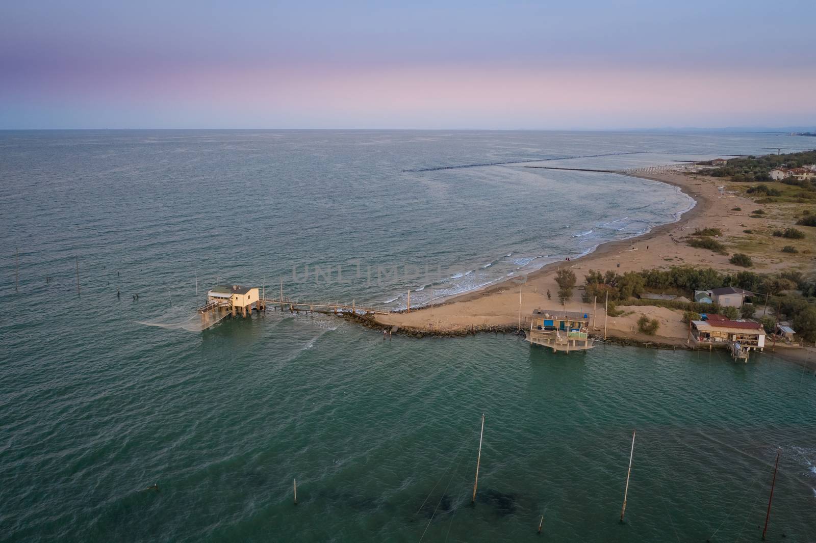 Landscapes shot of the valleys near Ravenna (Fiumi Uniti) where the river flows into the sea with the typical fishermen's huts at sunset