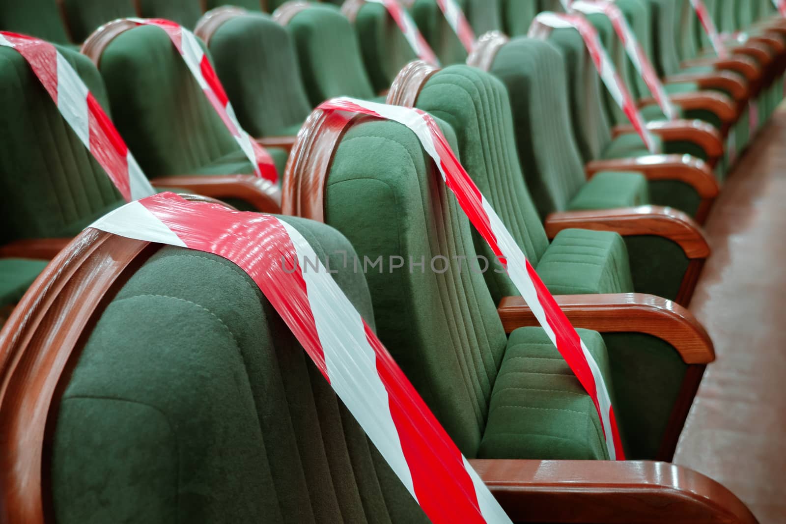 Background of empty seats in the cinema, theater, auditorium with a warning label. Presentation of a conference, opera, theatrical performance. Work during coronavirus, adhering to social distancing by synel