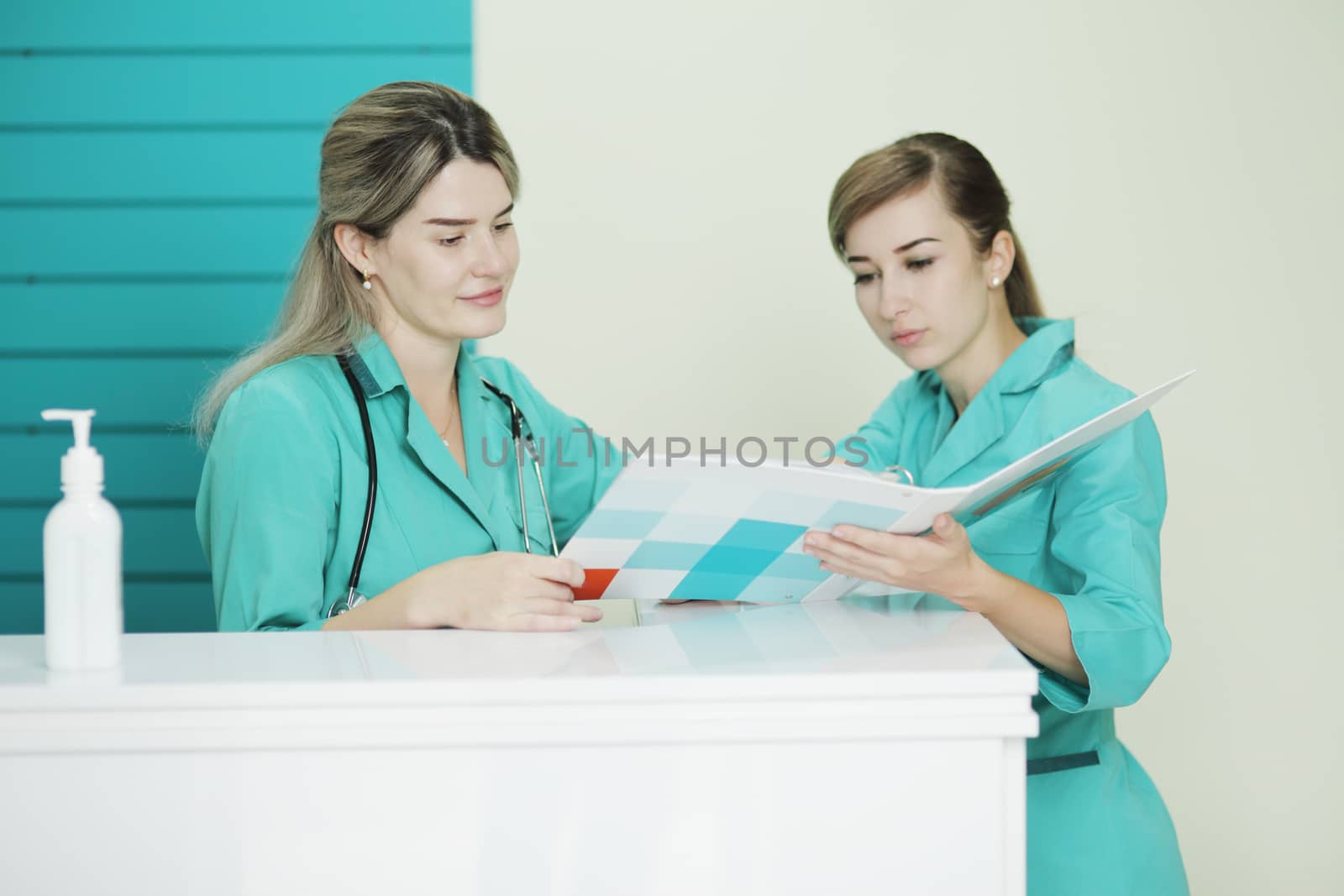 Two female doctor or nurse discussing patient treatment. Stethoscope on the neck by selinsmo