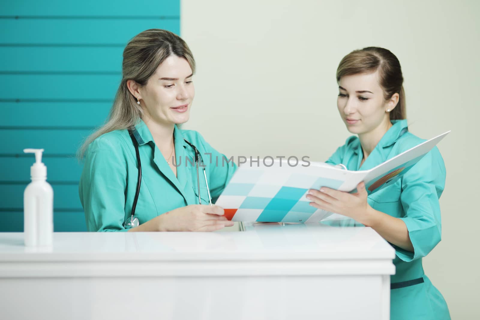 Two female doctor or nurse discussing patient treatment. Stethoscope on the neck by selinsmo