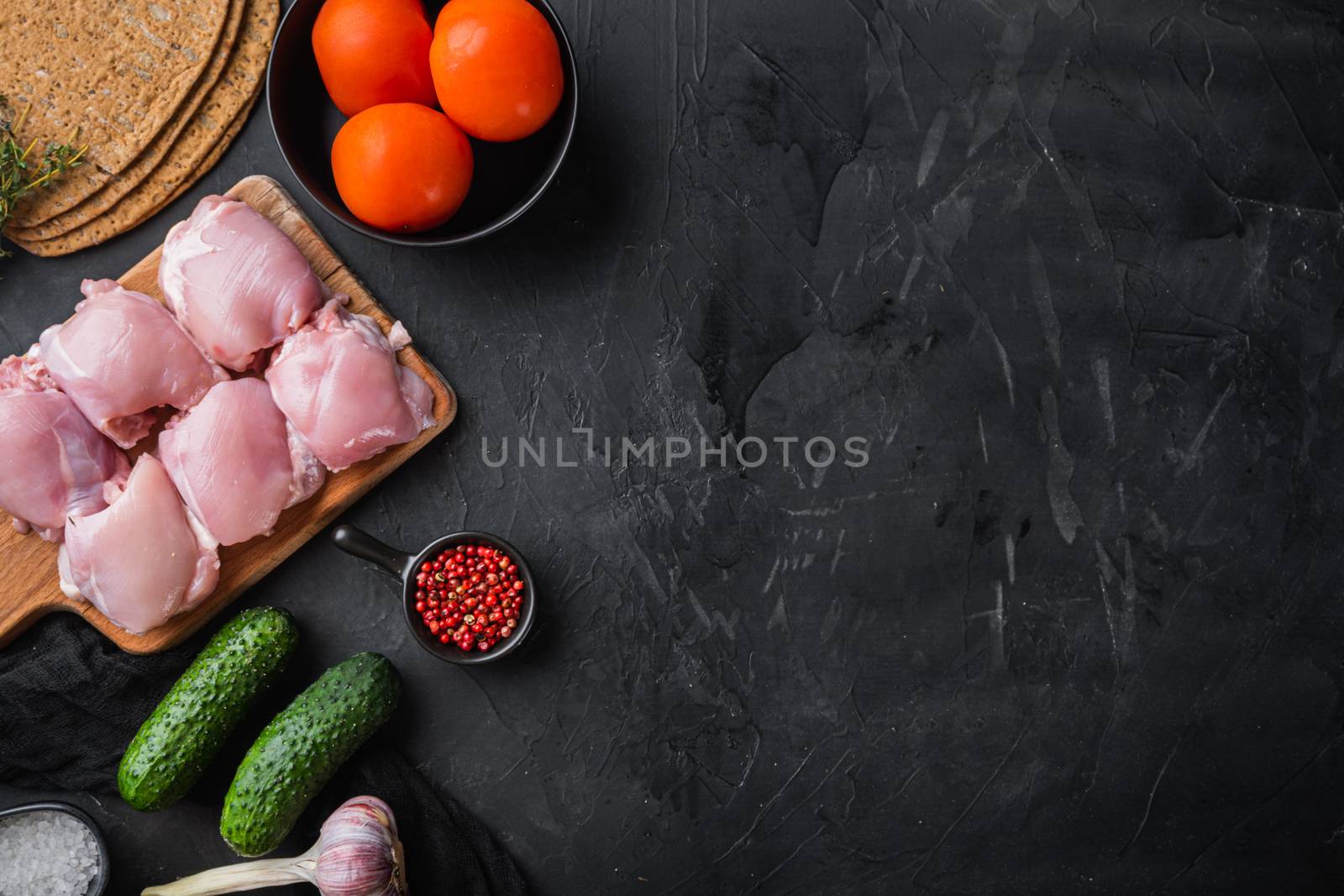 Shawarma ingredients, chicken meat on black background, flat lay with copy space.