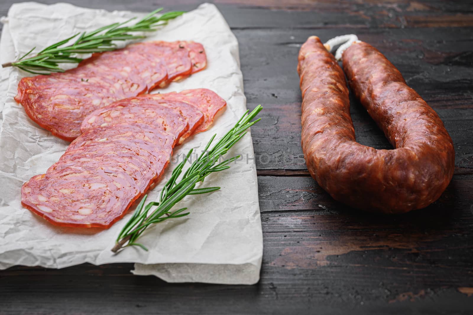 Chorizo, spanish traditional sausage cut to slices on old wooden table.