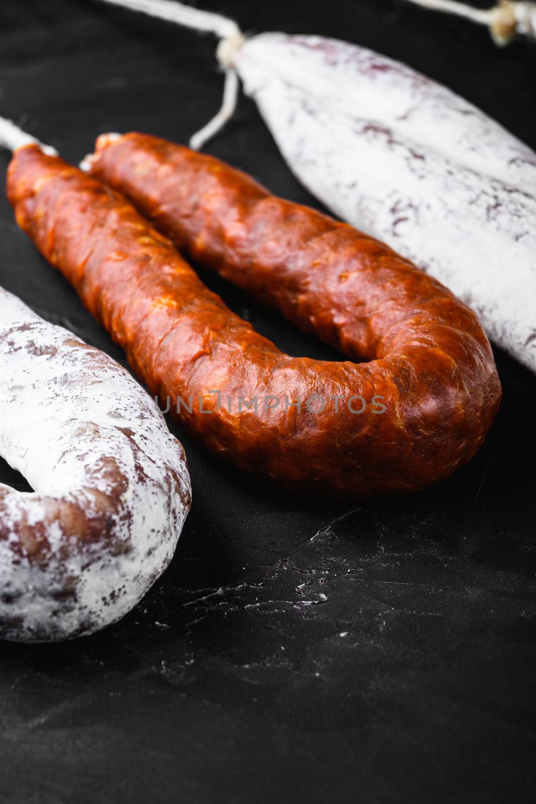 Traditional spanish sausages fuet and chorizo on black background.