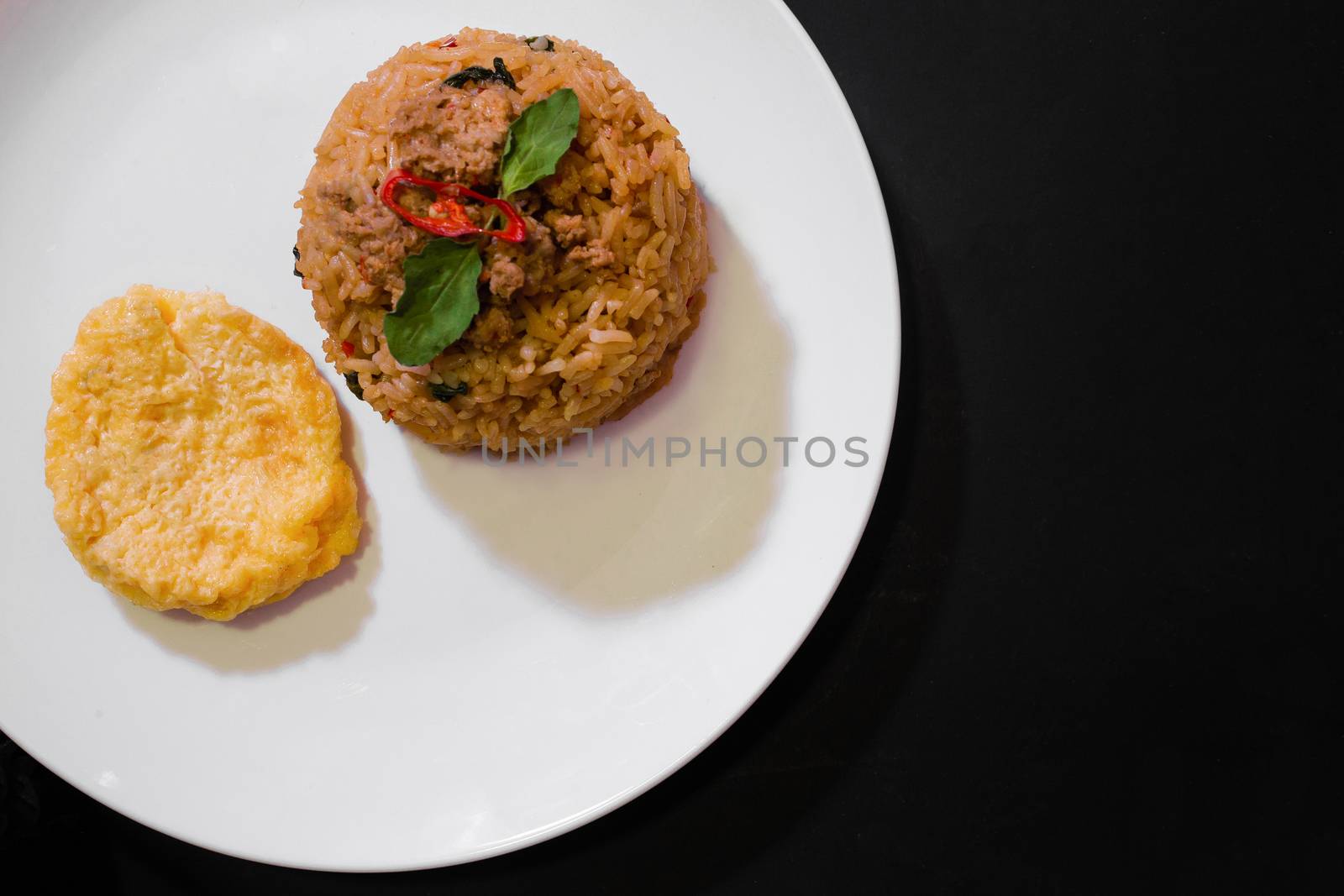 Basil pork fried rice and omelet egg on black background, Thai food, Street food, Image from the top view