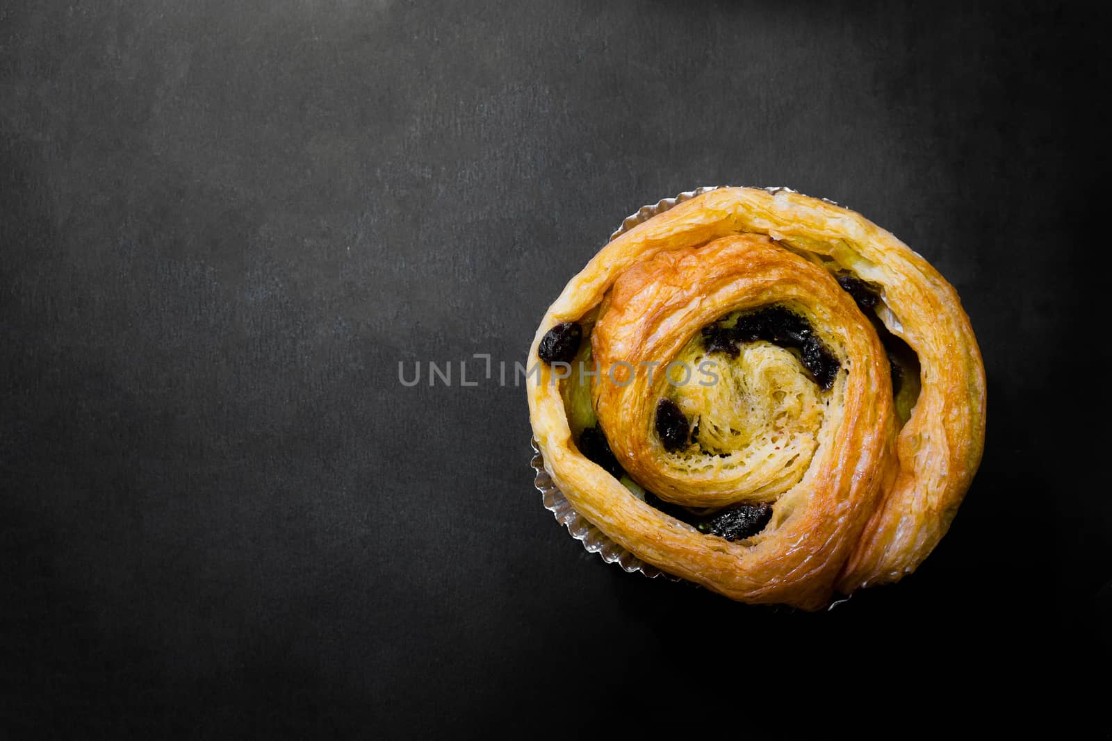 Raisin Bread on a black background, Cinnamon Roll, Butter and Raisin, Homemade Fresh Bakery Idea, Image from the top view