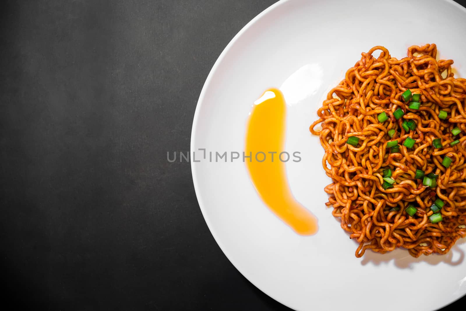 Korean spicy hot instant noodles on a black background, picture from the top view of instant noodles