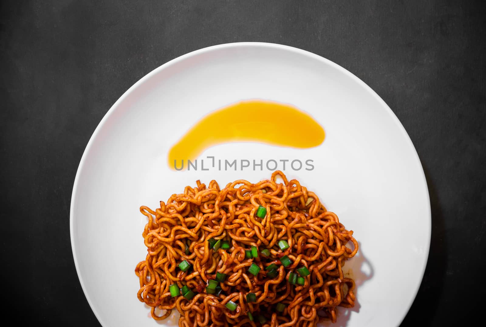 Korean spicy hot instant noodles on a black background, picture from the top view of instant noodles