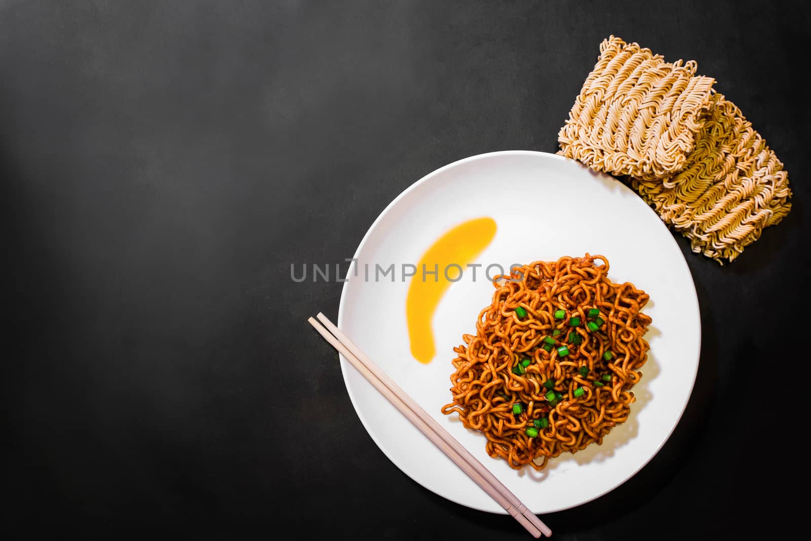 Korean spicy hot instant noodles on a black background, picture from the top view of instant noodles