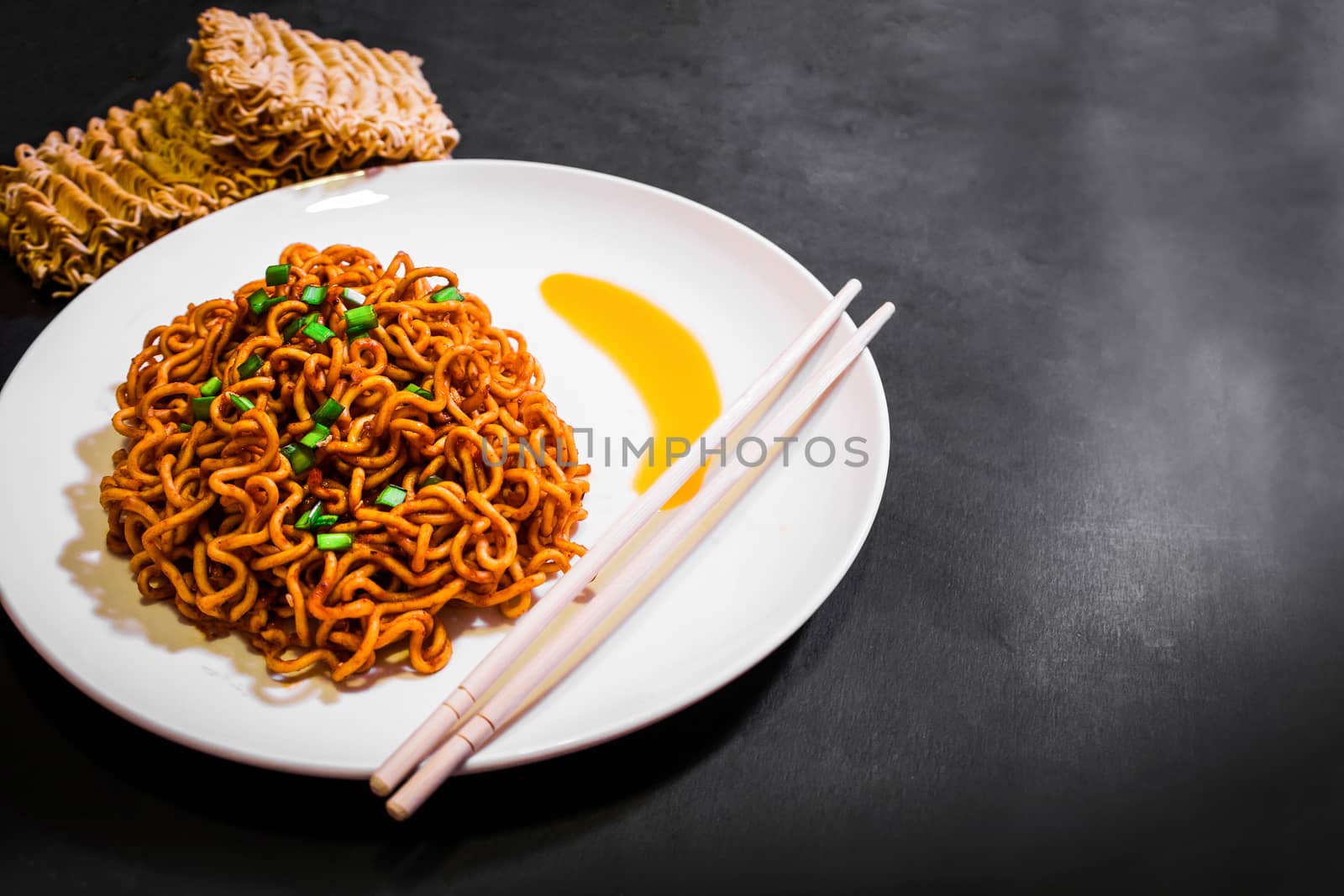 Korean spicy hot instant noodles on a black background, picture from the top view of instant noodles