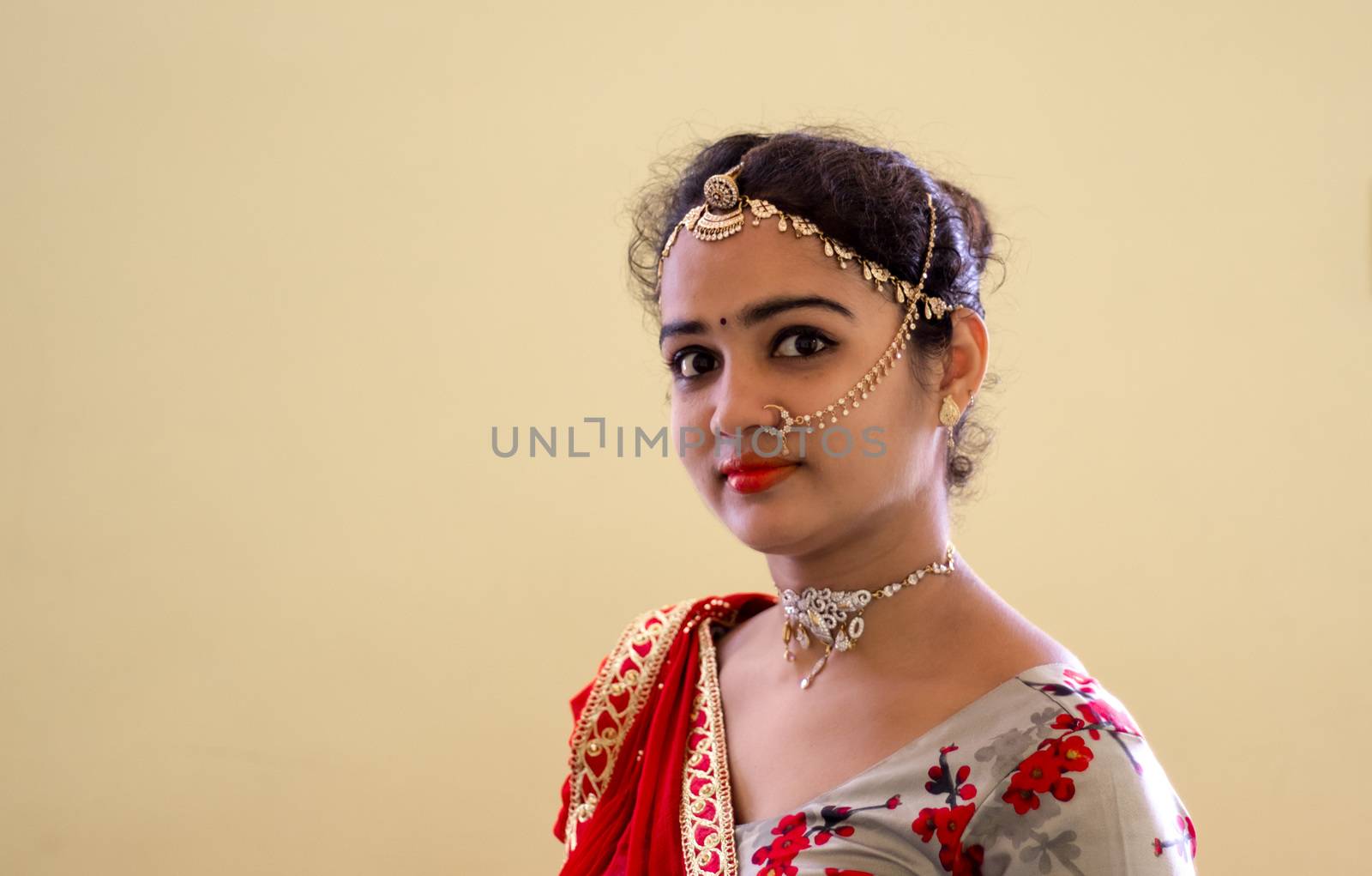 A beautiful young Hindu woman wore gold ornaments and a Colorful floral design choli and red odani according to her traditions and customs.