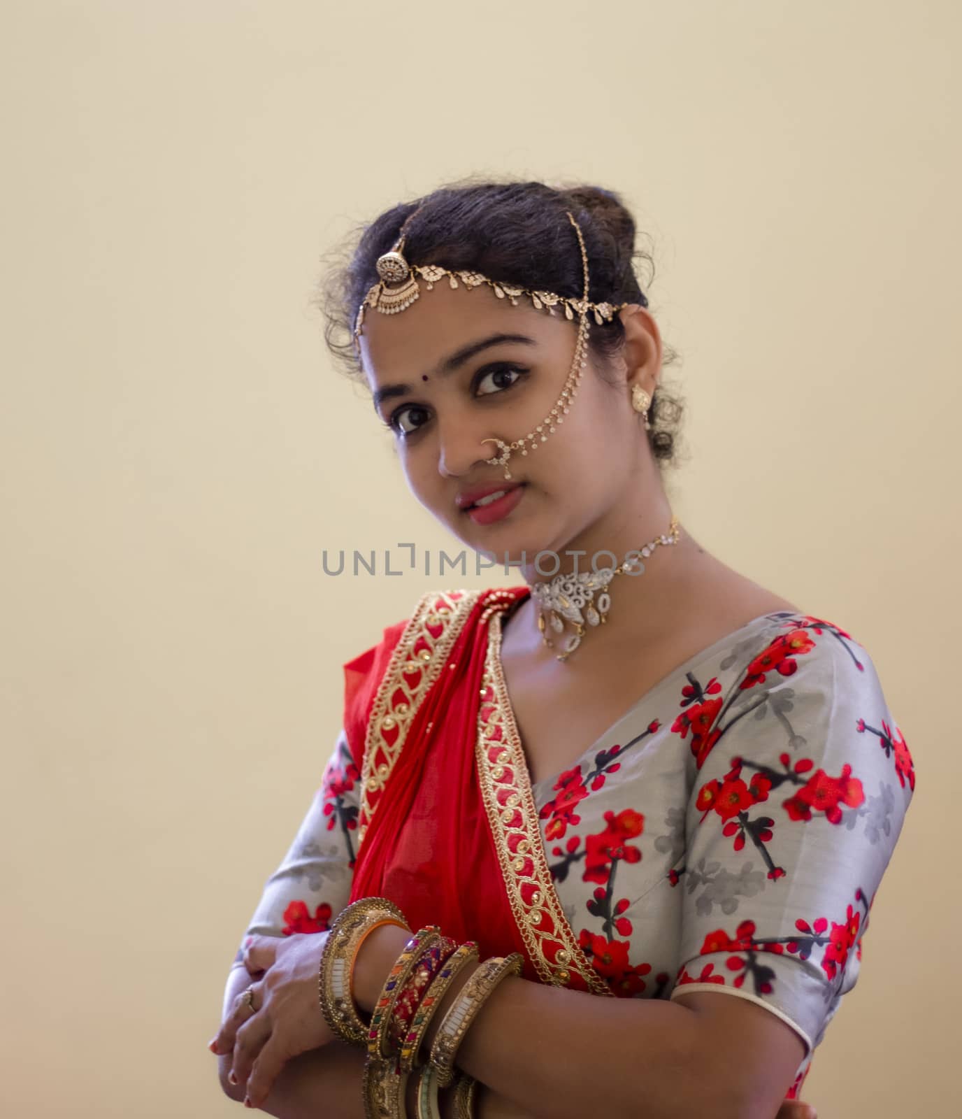 A beautiful young Hindu girl with gold ornaments according to her traditions and customs and red lipstick on her attractive soft lips