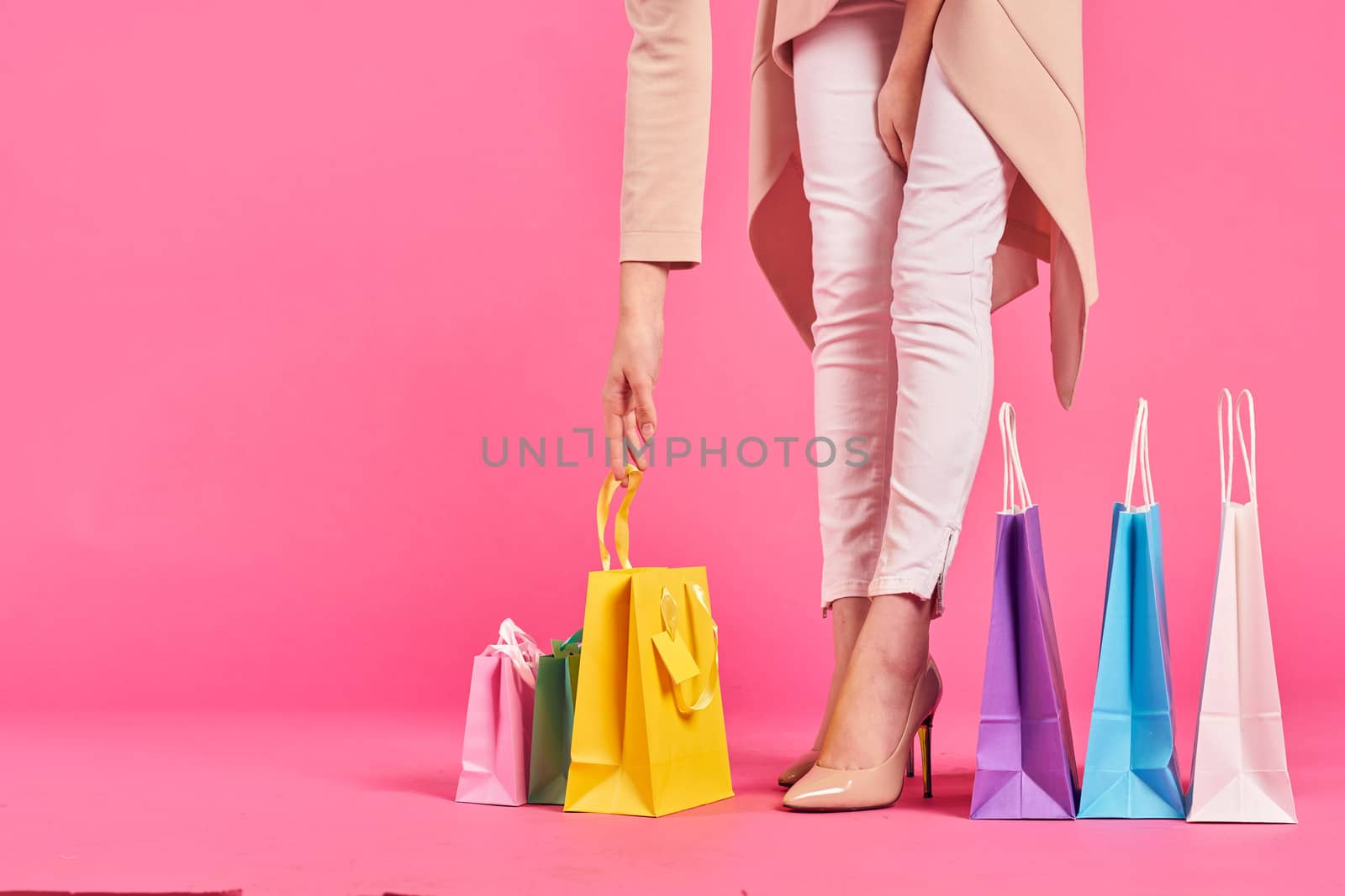 shopping bags female feet in shoes Shopaholic pink background. High quality photo