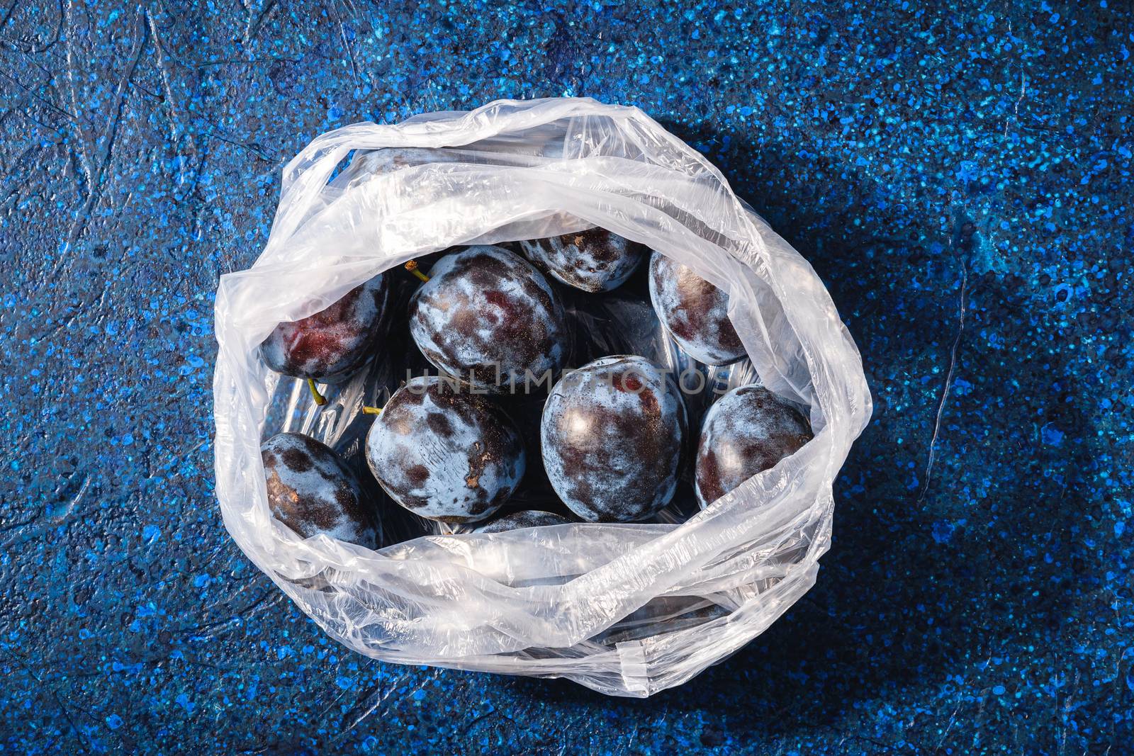 Fresh ripe plum fruits in plastic bag package by Frostroomhead