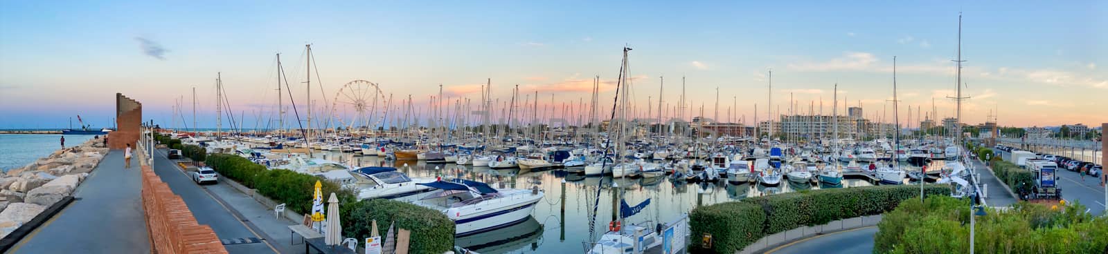 RIMINI, ITALY - AUGUST 26, 2020: Sunset view of city port and boats.