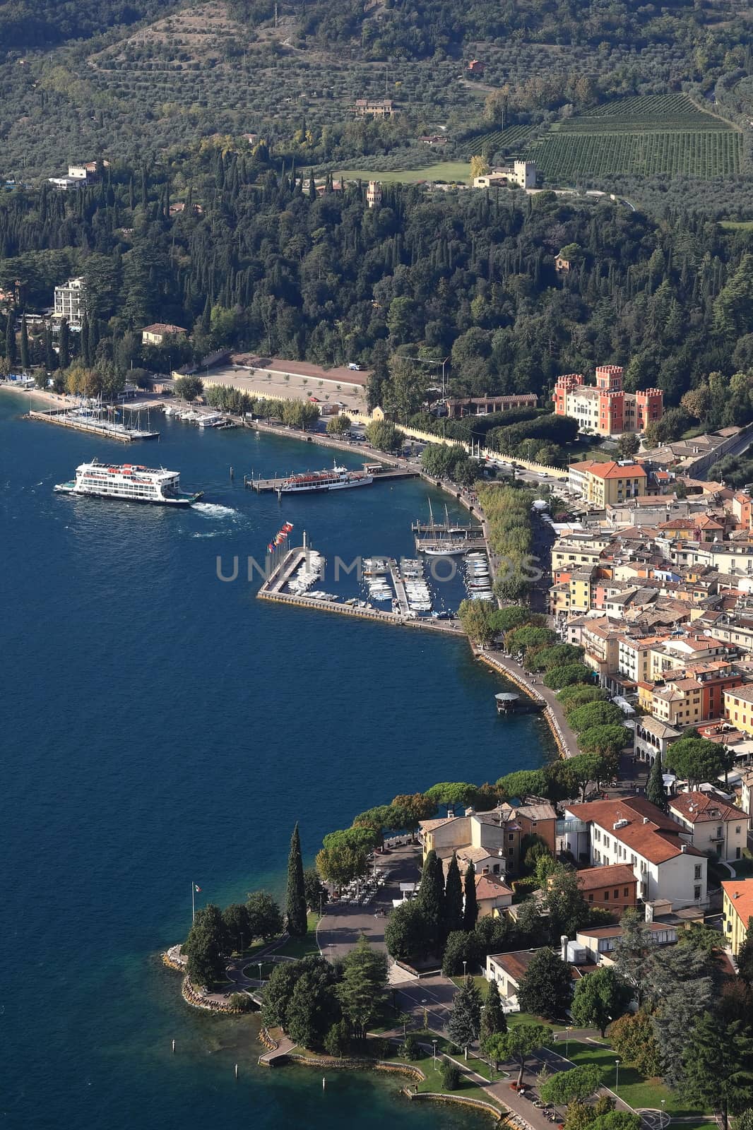 The view from Rocca across the town of Garda as a ferry departs the waterfront.  Garda is a town on the edge of Lake Garda in North East Italy and Rocca is a hill overlooking the town.