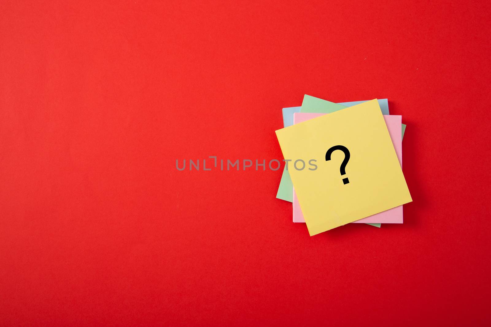 Question mark drawn on notepad. Over red background with copy space.