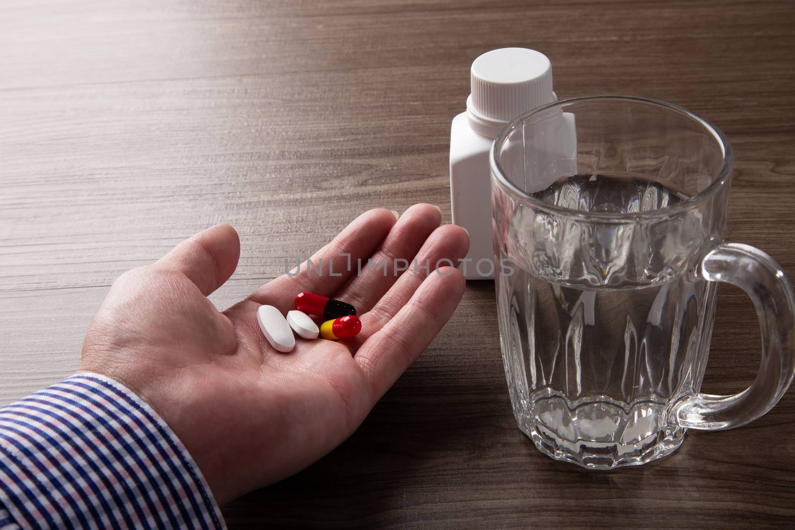close up of senior man hand taking pills