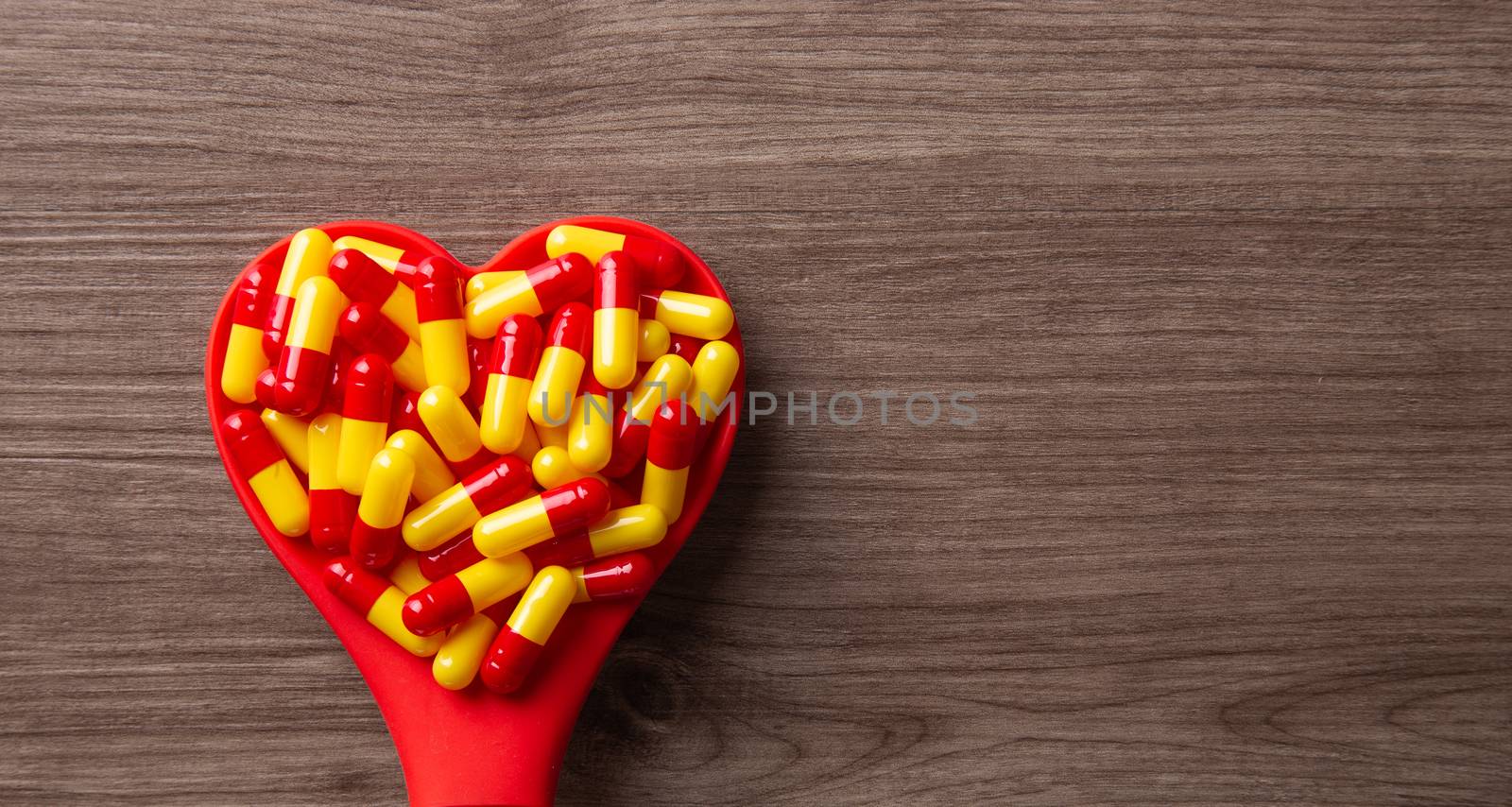 Pill on love shape spoon. health care conceptual
