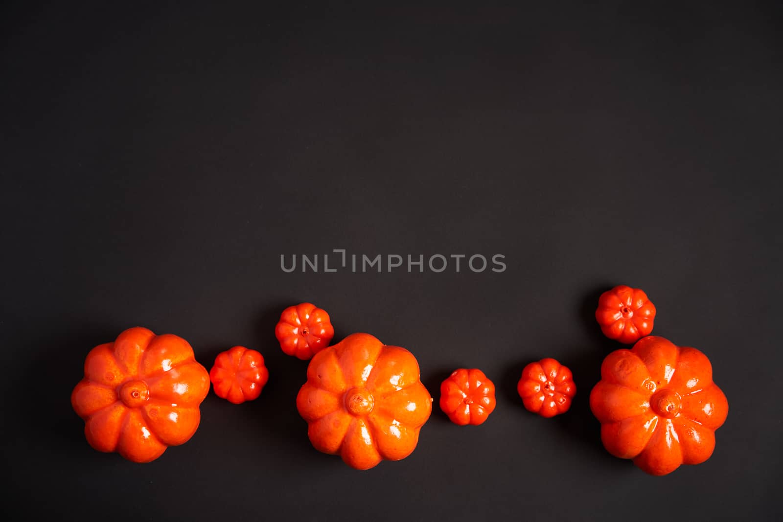 Halloween background, orange decorative plastic pumpkin black paper Thanksgiving greeting card pattern