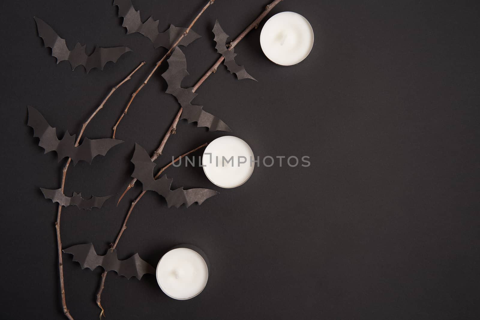 Halloween decoration concept black paper bats dry branch stick black cardboard background With copy space for tetxt