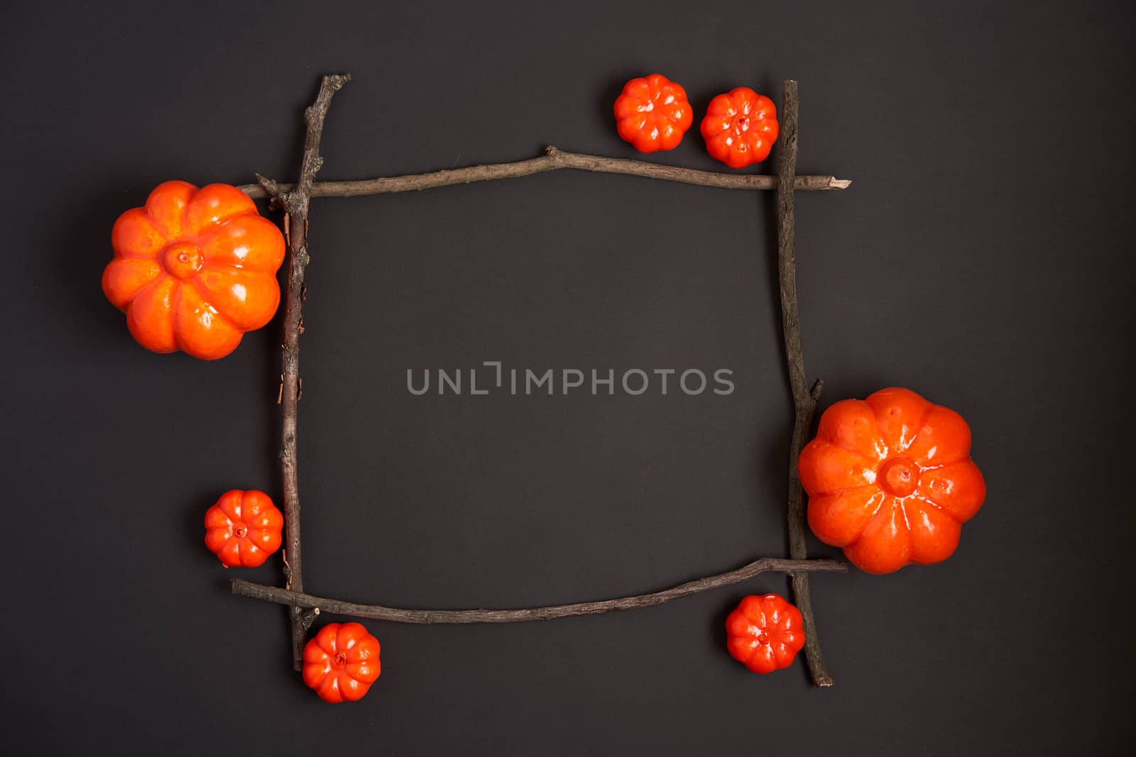 Halloween background, orange decorative plastic pumpkin black paper dry branch stick square frame black cardboard Thanksgiving greeting card pattern