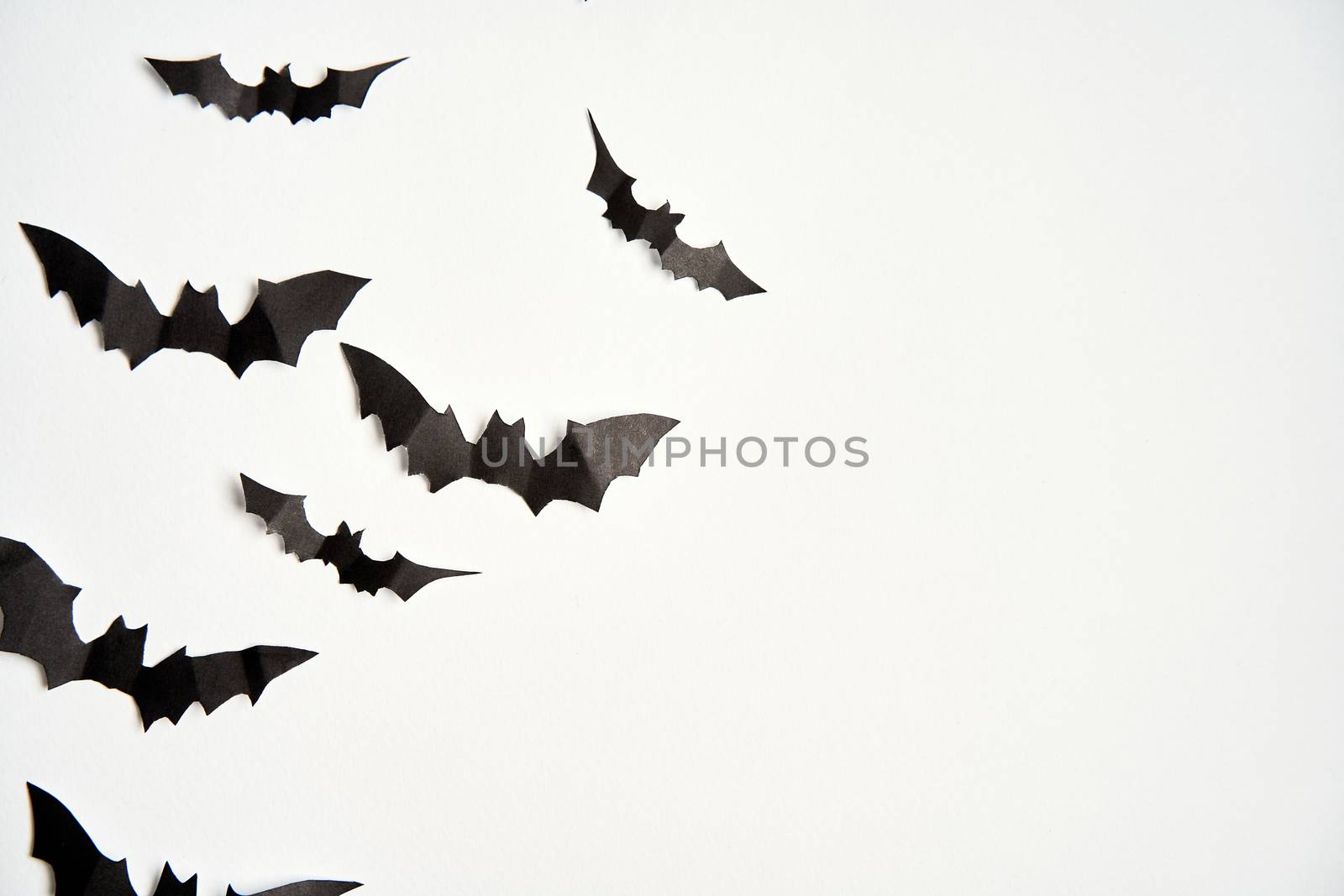 Halloween decoration concept black paper bats white cardboard background With copy space for tetxt