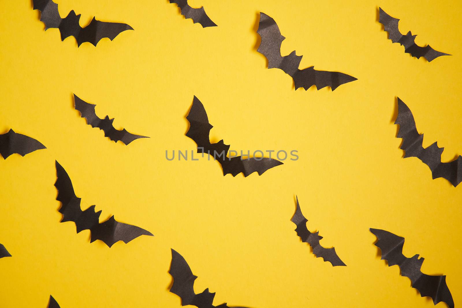 Halloween decoration concept black paper bats yellow cardboard background Pattern