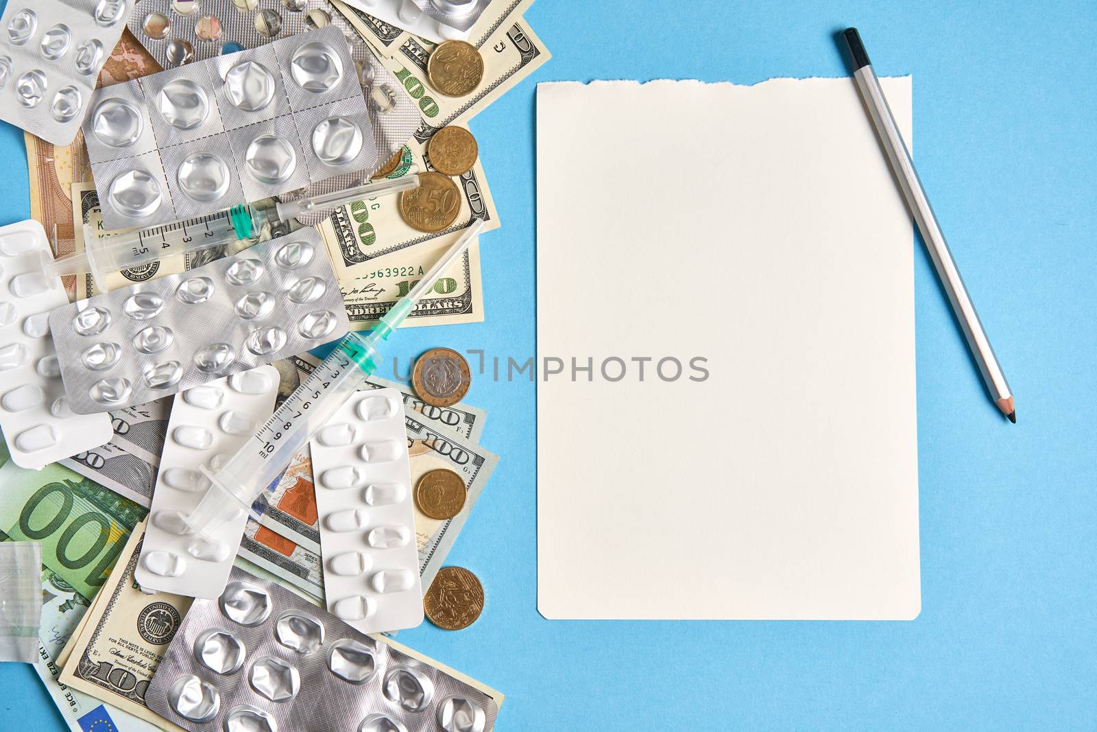 pills empty blisters for drugs individual syringe and money lie on a blue background Expensive medicine health insurance concept. Expensive treatment of diseases. Budget for medical expenses. Notebook