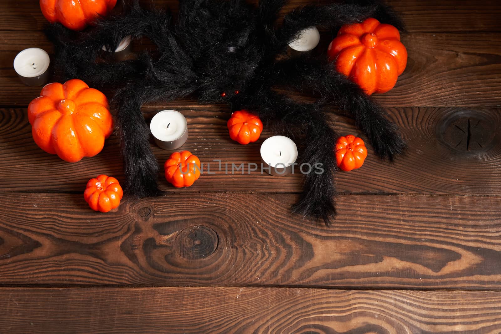 Halloween background, orange decorative plastic pumpkin black shaggy hairy big toy spide black cardboard Thanksgiving greeting card pattern