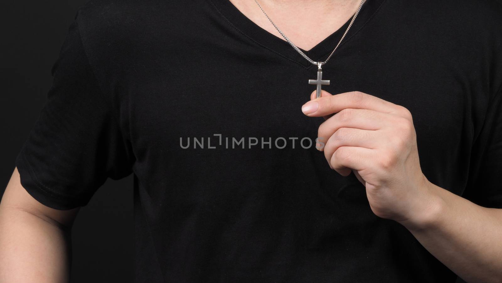Crucifix pendant or cross sign made from silver and hold in man  by gnepphoto
