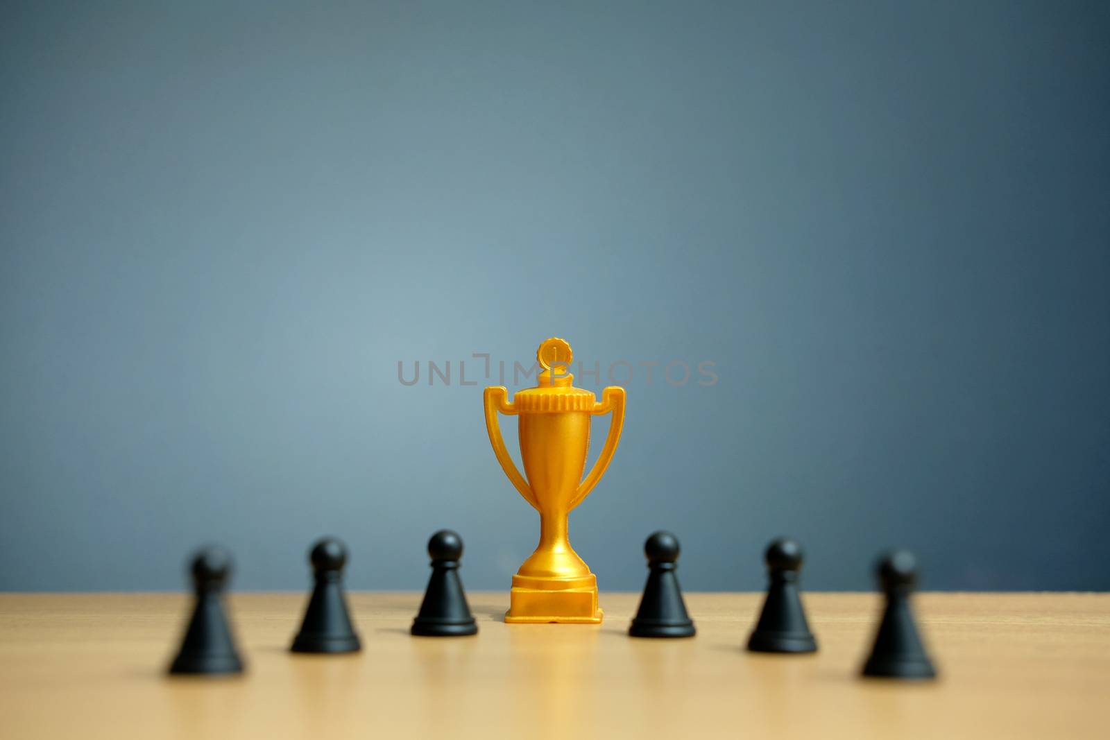 Golden trophy in the middle of chess pawn